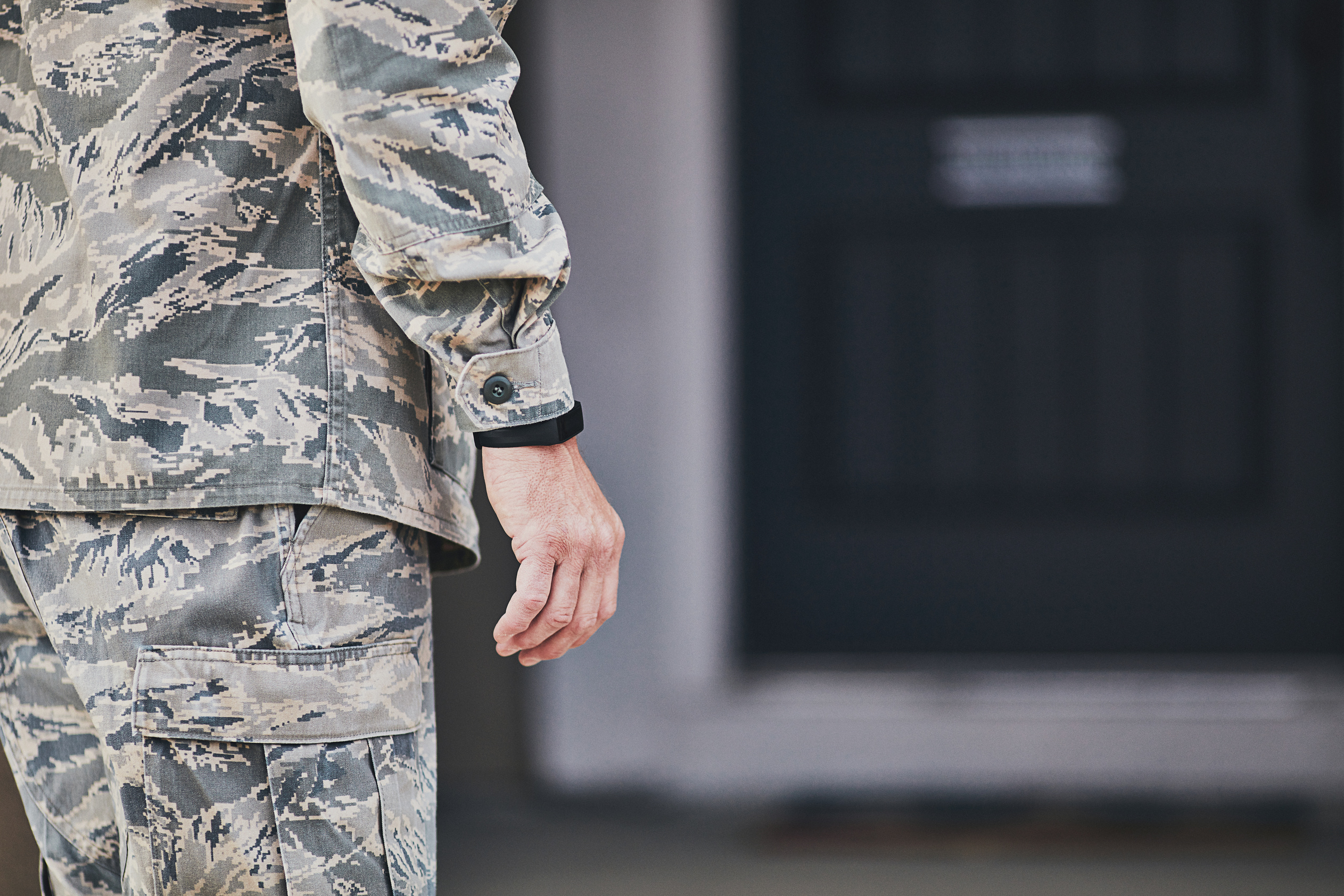 Military service member wearing fitness tracker arriving home from work
